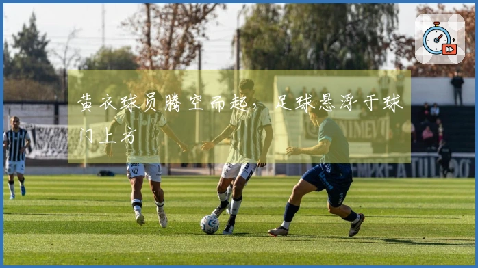 黄衣球员腾空而起，足球悬浮于球门上方